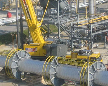 Industrial facility construction with crane and piping